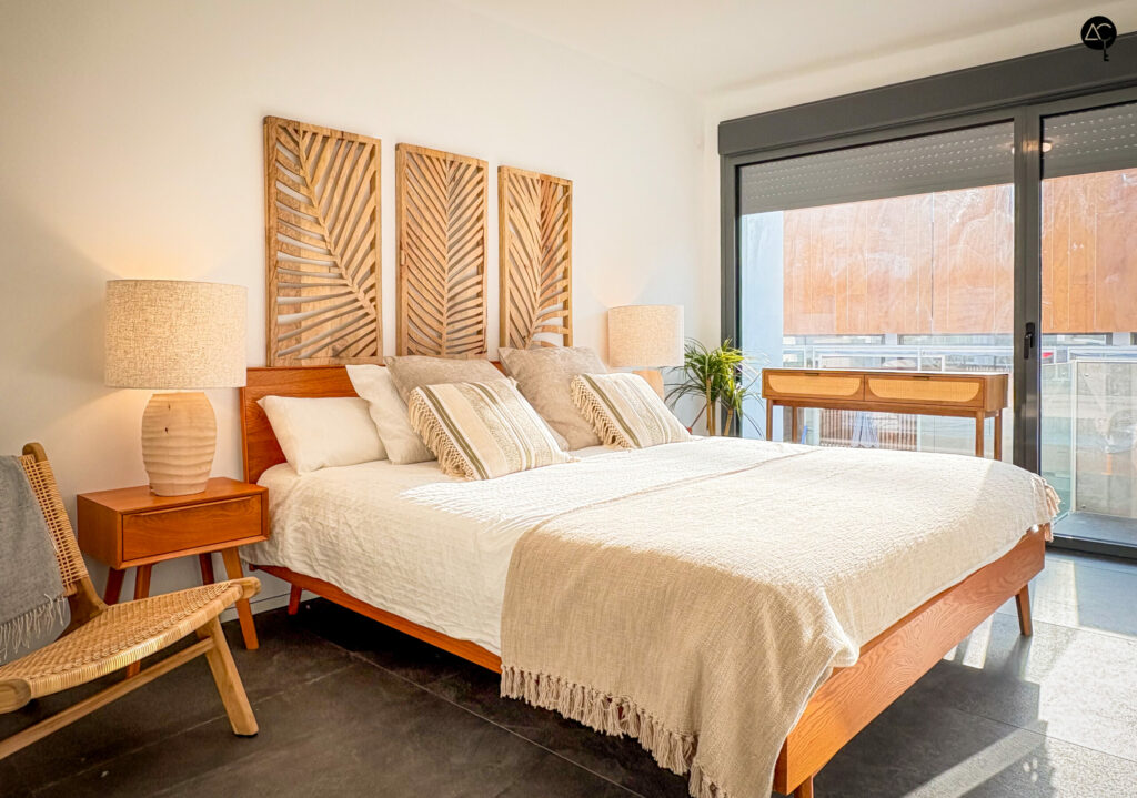 Habitación en tonos cálidos con ventanal y cama de matrimonio
